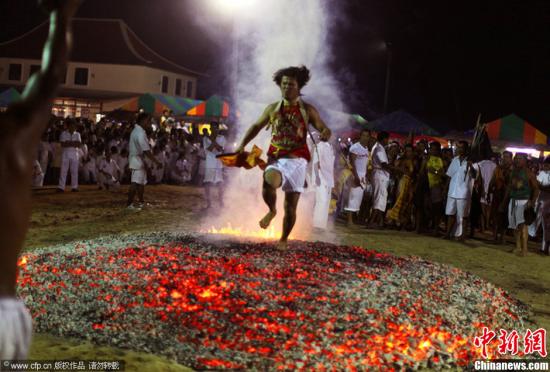 当地时间2013年10月10日，泰国普吉岛，素食节期间泰国信徒表演“下火海”，光脚在烧红的炭木上跑过。图片来源：CFP视觉中国